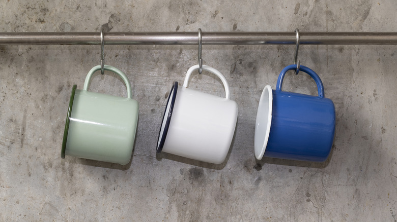 Mugs hanging from a towel rack