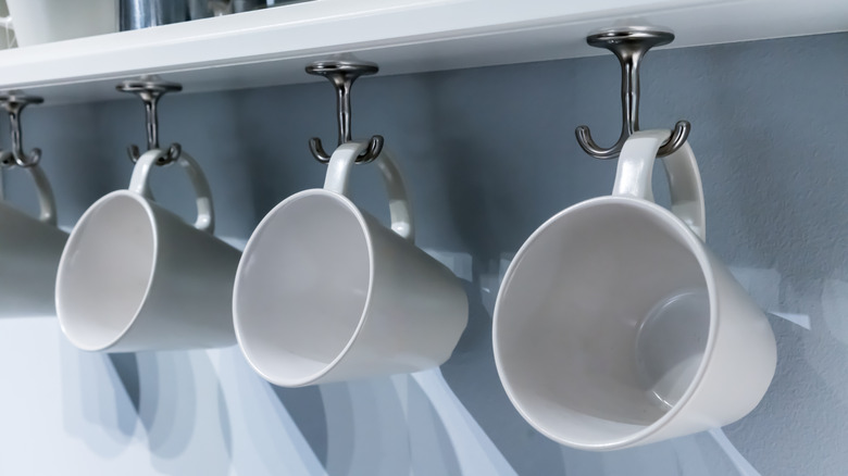 Under-cabinet cup hooks with mugs hanging on them