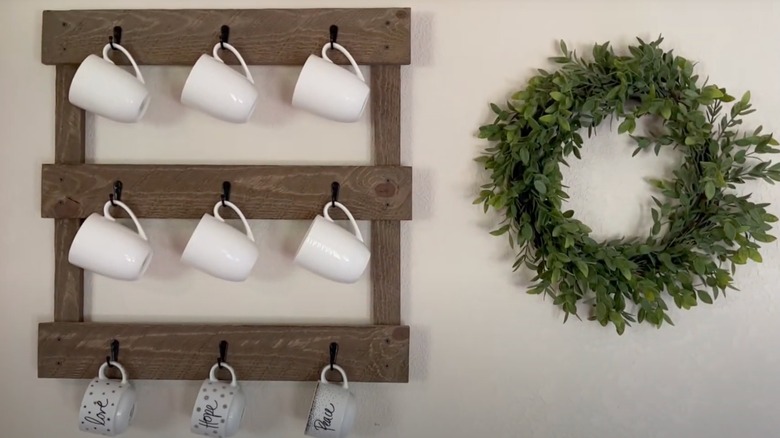 Mug rack on wall beside wreath