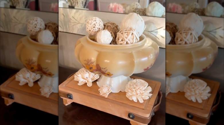 Glass lampshade turned upside down to use as pedestal bowl with decorations inside.