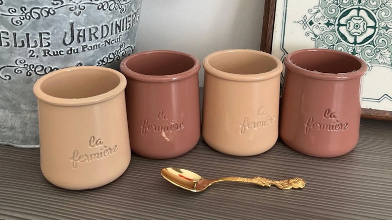 brown and beige yogurt cups on a table with a golden spoon