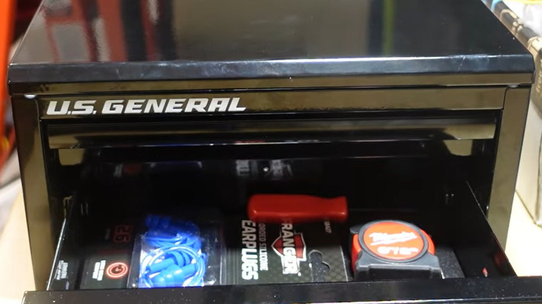 Tape measure, earplugs, and screwdriver in U.S. General mini toolbox