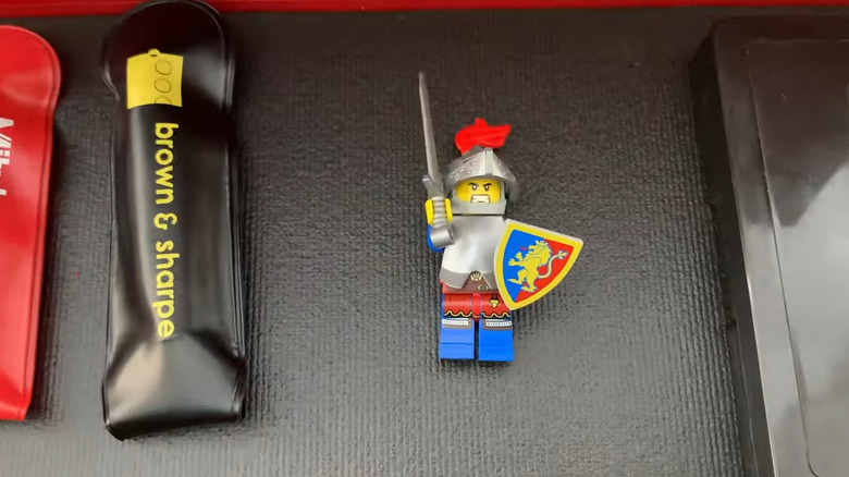 Lego man holding sword and shield inside mini toolbox