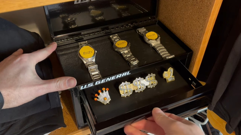 Watches and pins organized in mini toolbox in closet