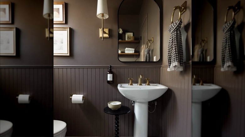 Brown bathroom with white sink and golden fixtures