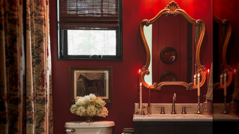 red bathroom with candles and vintage mirror