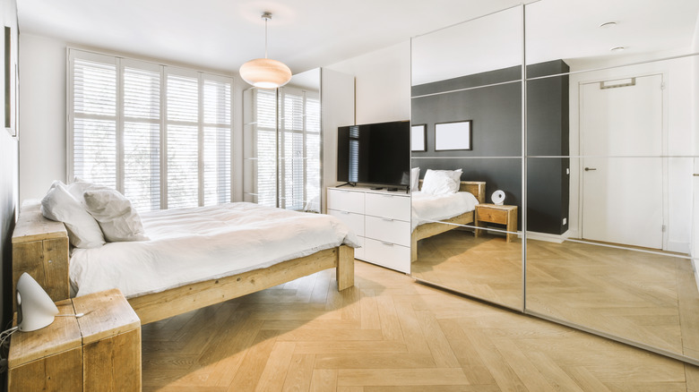 bedroom with mirror wall closets