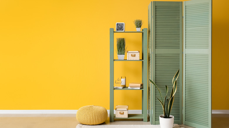 Yellow accent wall with olive green furniture
