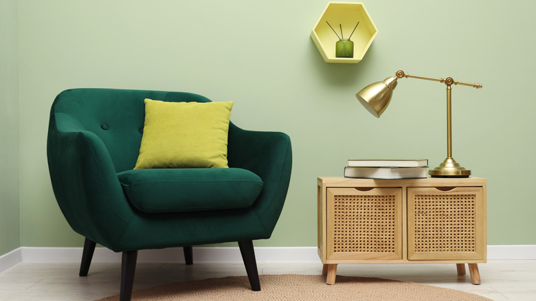 Green armchair in front of an olive green wall