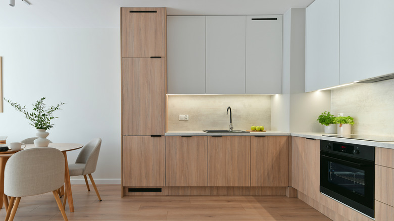 Light kitchen with wood and white cabinets and built-in oven