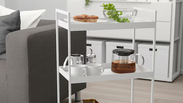 White utility cart with breakfast snacks and coffee pot and mugs
