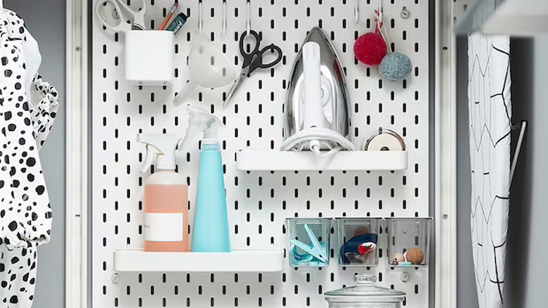 IKEA pegboard with assorted housewares including sewing, ironing, and cleaning