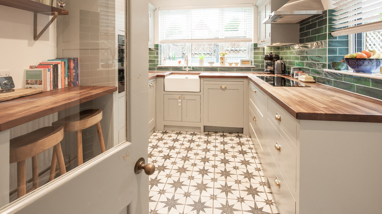 Neutral kitchen with white cabinets and white and green checkered tile floor