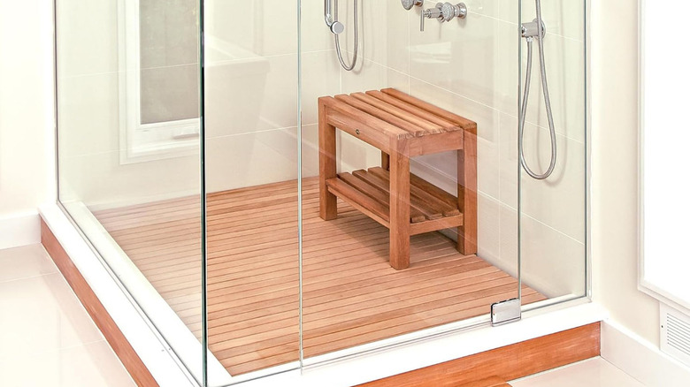 A teak wood slated shower insert with a bench to match