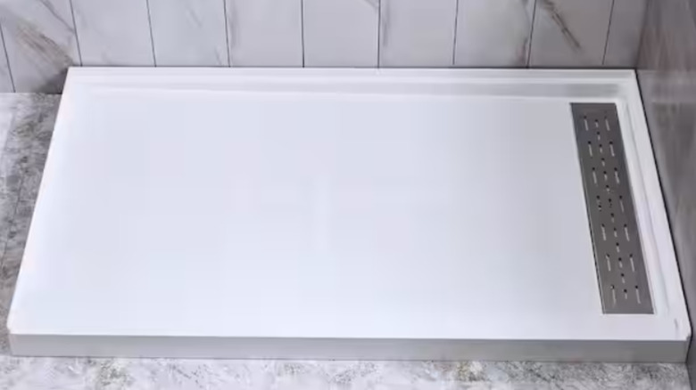 A solid surface alcove shower pan base in white.