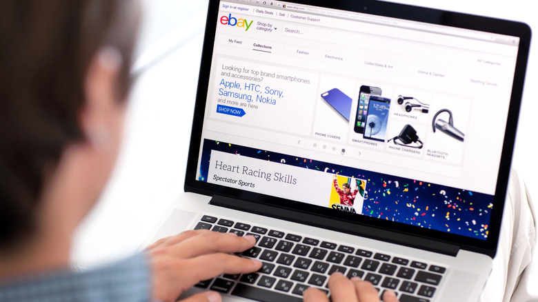 Man sitting at a laptop with his browser open to the front page of eBay