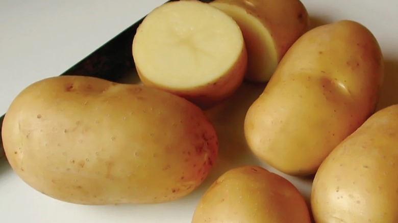 Four whole carola potatoes with one carola potato cut in half