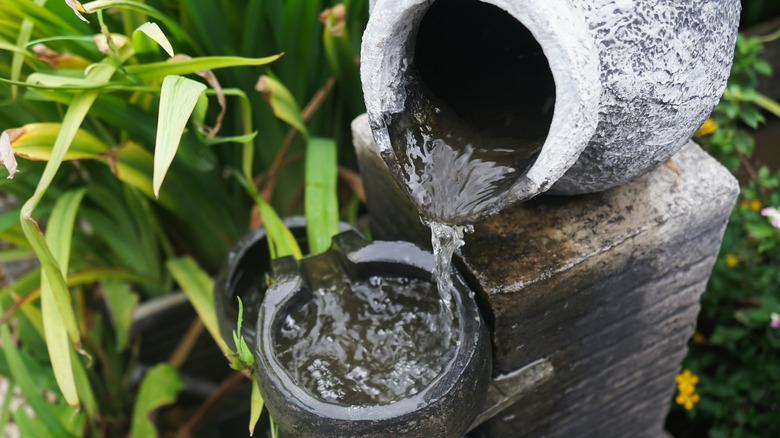 Garden fountain made of jugs pouring water into each other
