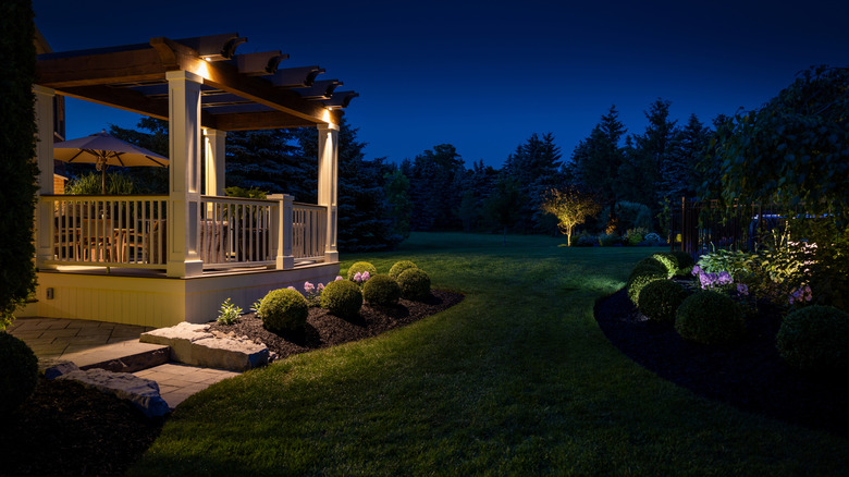 A backyard at night with outdoor lights