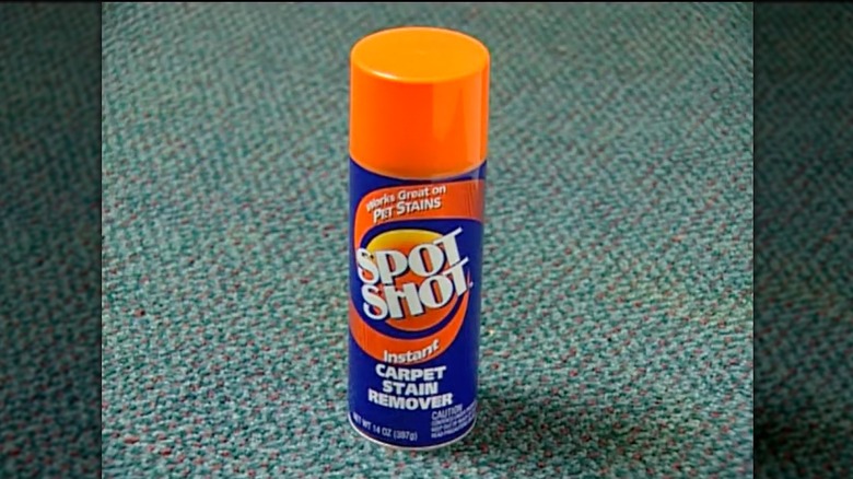 A can of Spot Shot sits on a blue and red carpet.