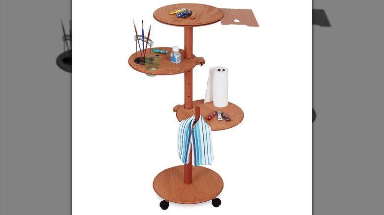A multi-tiered plant stand used for art supplies