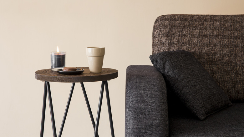 A small side table sits next to a brown couch