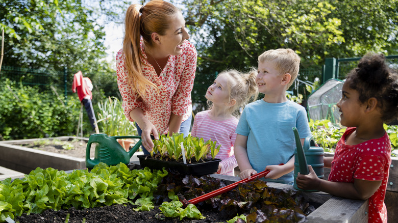 A teacher and children in a garden