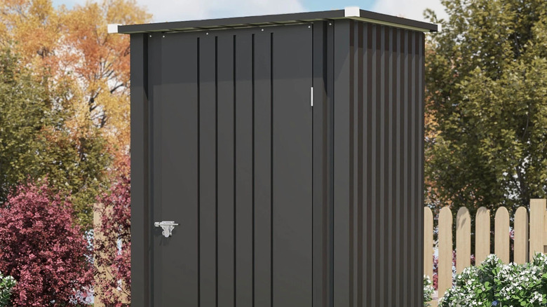 Black outdoor shed with lockable door in yard