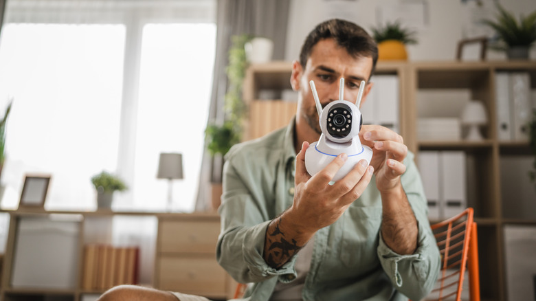 man examining home security camera