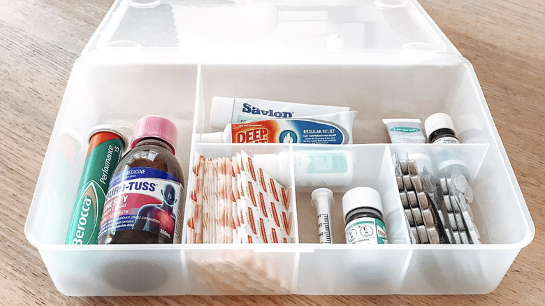 A first aid kit full of supplies made from a clear IKEA GLIS box with dividers.