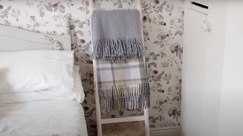 A blanket ladder with grey and plaid throws