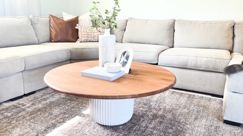 A coffee table crafted from a planter and piece of wood