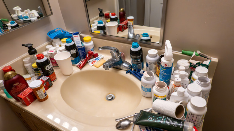 A bathroom vanity countertop covered in personal hygiene products.