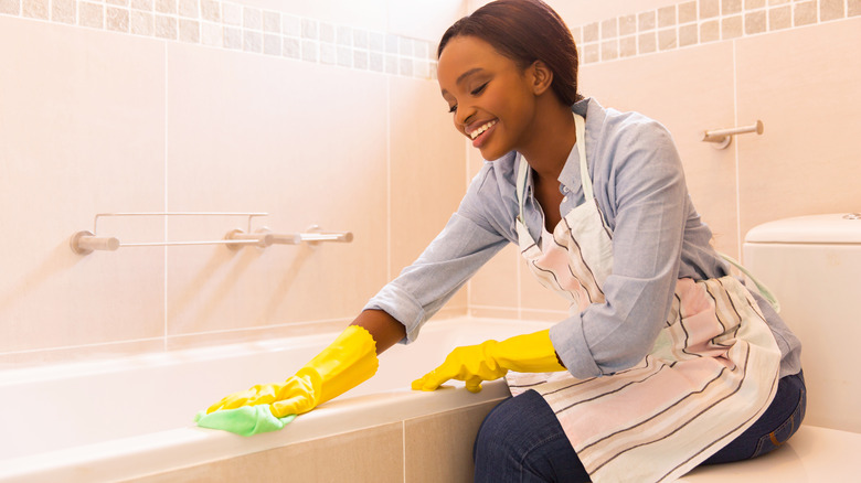 Woman cleaning the bathtub