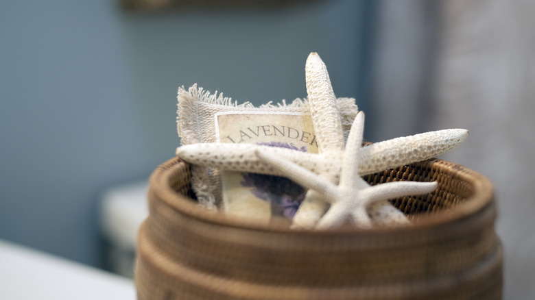 A bowl filled with dried starfish and a pouch of lavender