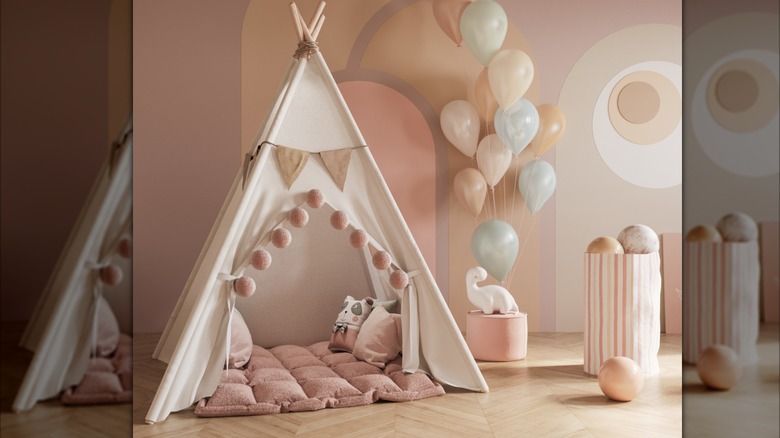 A child's play space with a play tent, balloons, and toys around the space.