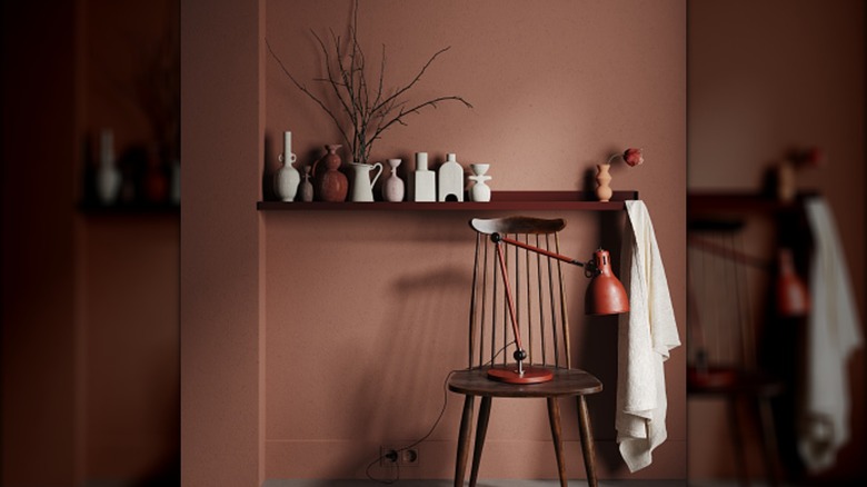 A mudroom with a single chair and wooden shelf with small clay trinkets on it.