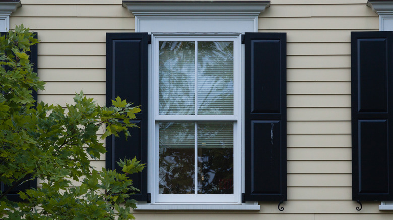 glossy black shutters on a cream colored house