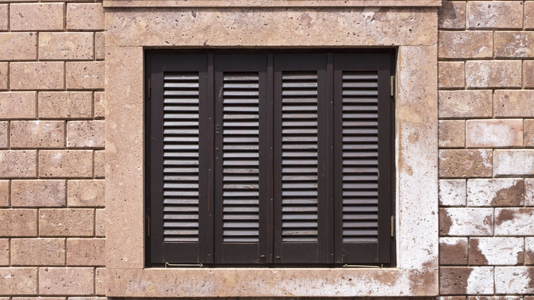 dark brown shutters on stone home
