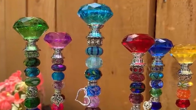 glass bottle topper beaded stake in garden