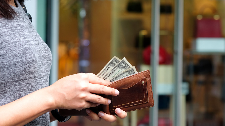 person paying with dollar bills