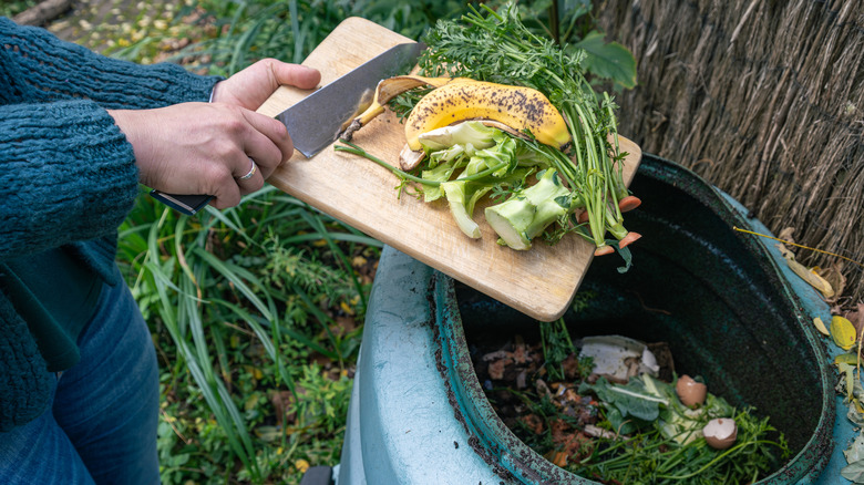 Woman disposing of kitchen scraps in the compost