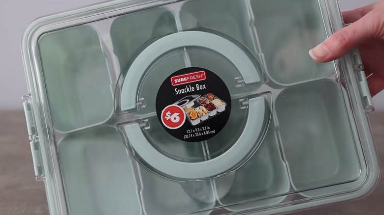 A closeup photo shows a compartmentalized snack box in a pastel green color