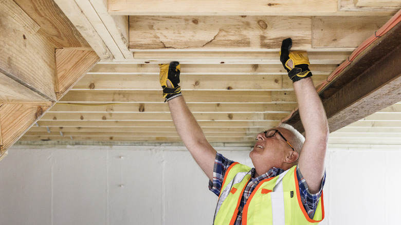 person working on exposed ceiling