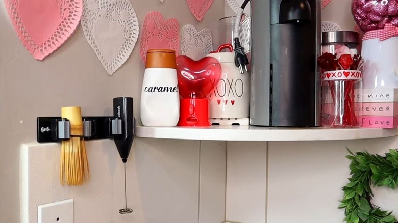 A Dollar Tree broom hanger holding a milk frother and matcha wisk at a coffee bar.