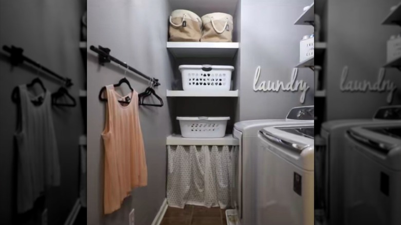 A small laundry room with a black drying rack on the left made from a Dollar Tree broom handle and broom hanger.