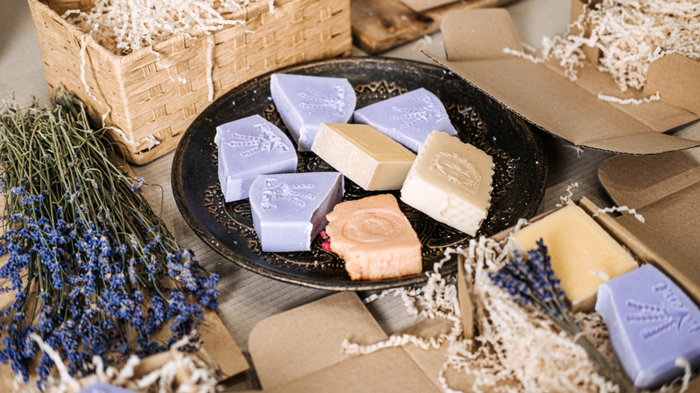 bar soap on a plate and packaging with lavender herbs