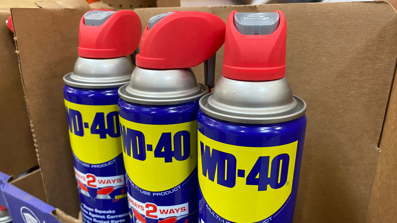 Three containers of WD-40 in a box