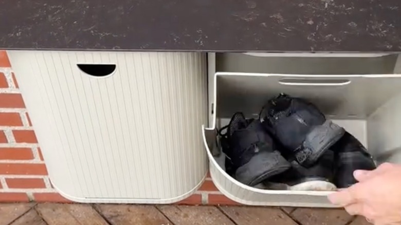 DIY bin used as shoe storage with a wooden plank on top