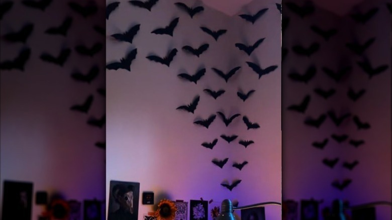 Wall decorated with paper bats and other Halloween supplies